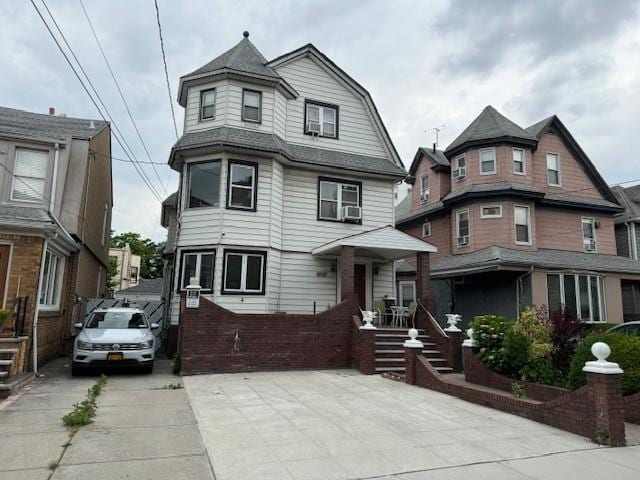 view of front of home featuring cooling unit and a gambrel roof