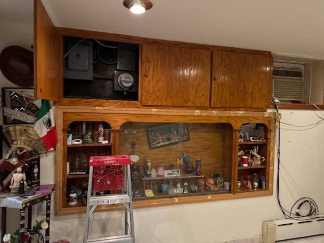 interior space with baseboard heating, electric panel, and a wall unit AC