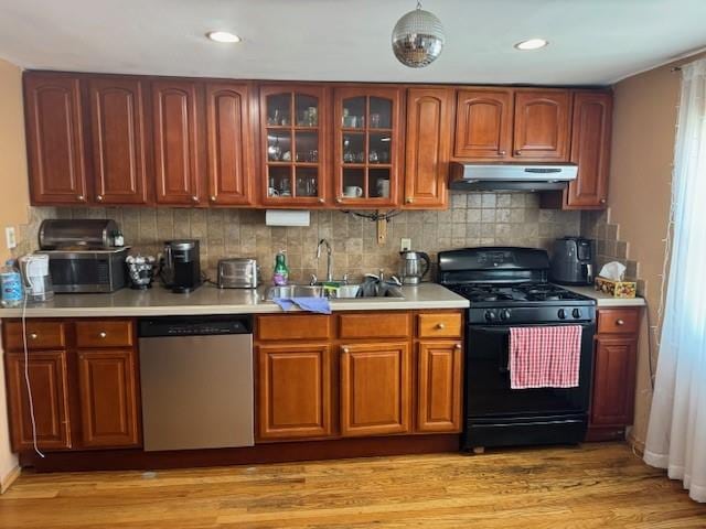 kitchen featuring light hardwood / wood-style floors, sink, backsplash, black range with gas cooktop, and stainless steel dishwasher