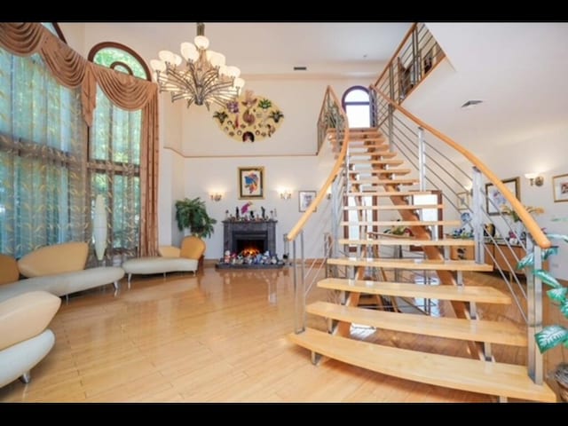 stairway with a high ceiling and a notable chandelier