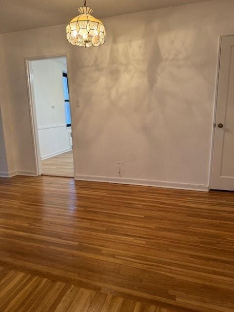 empty room with baseboards and wood finished floors