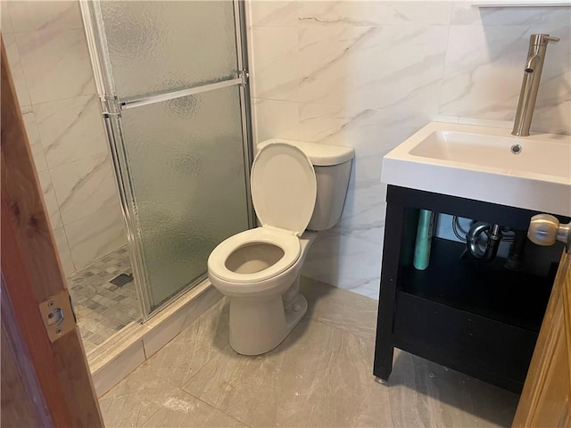 bathroom featuring toilet, vanity, tile walls, and walk in shower