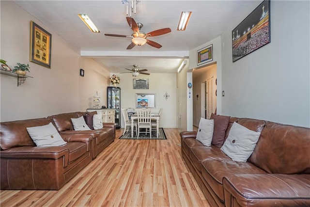 living room featuring beamed ceiling, ceiling fan, and light hardwood / wood-style floors