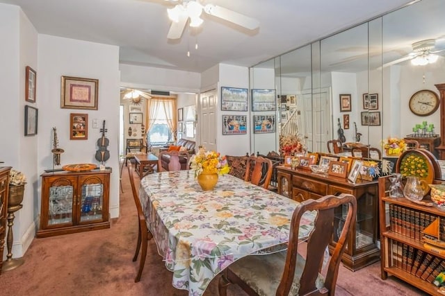 dining space with ceiling fan and carpet