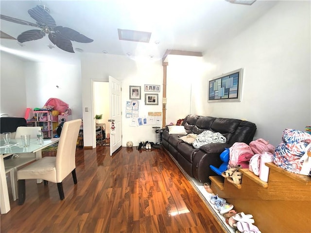 living room with a skylight, ceiling fan, and dark hardwood / wood-style flooring