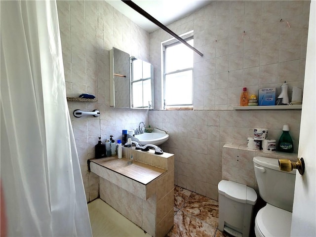 bathroom with curtained shower, tile walls, and toilet