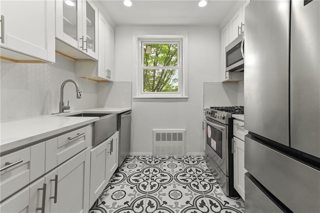 1021 E 87th St Unit 6B, Kings, NY 11236 - kitchen with stainless steel appliances, light countertops, baseboards, white cabinetry, and backsplash
