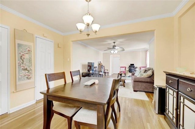 dining area with ornamental molding, ceiling fan with notable chandelier, and light hardwood / wood-style flooring