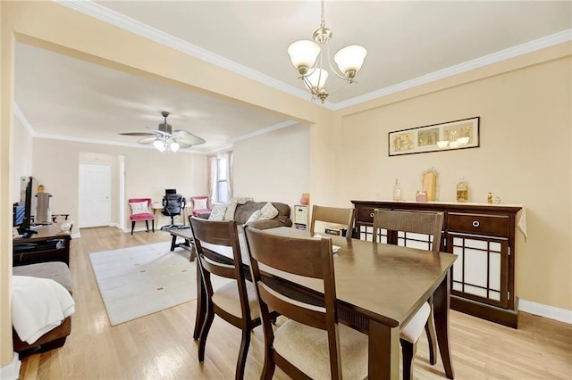 dining space with ceiling fan with notable chandelier, light wood-type flooring, and crown molding