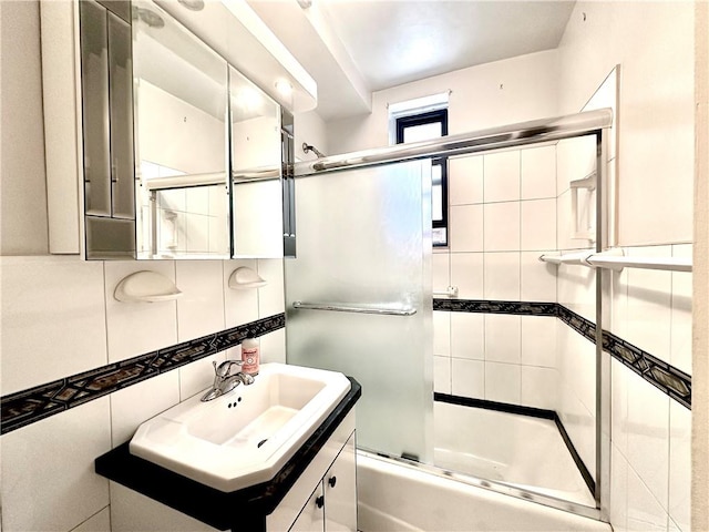 bathroom featuring enclosed tub / shower combo, tile walls, decorative backsplash, and vanity