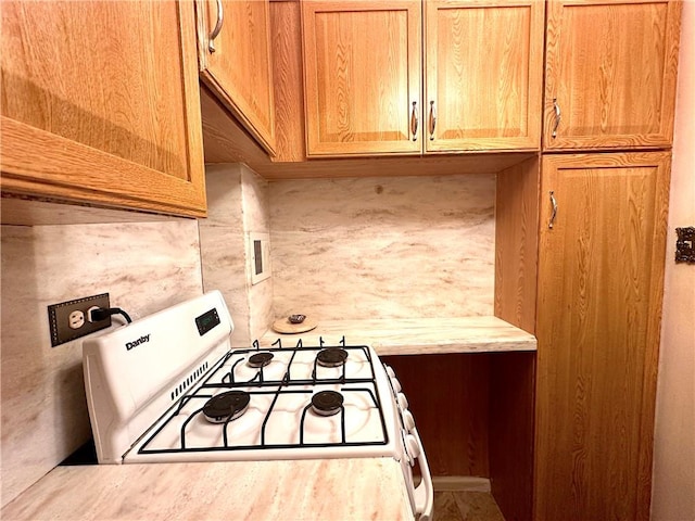 kitchen featuring white range with gas cooktop and light countertops