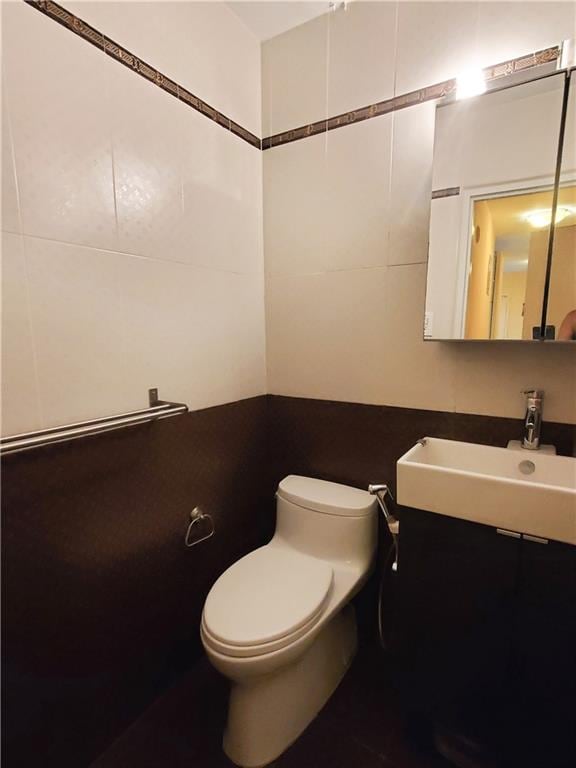 2475 W 16th St Unit 5A, Brooklyn, NY 11214 - half bathroom featuring toilet, a sink, and tile walls