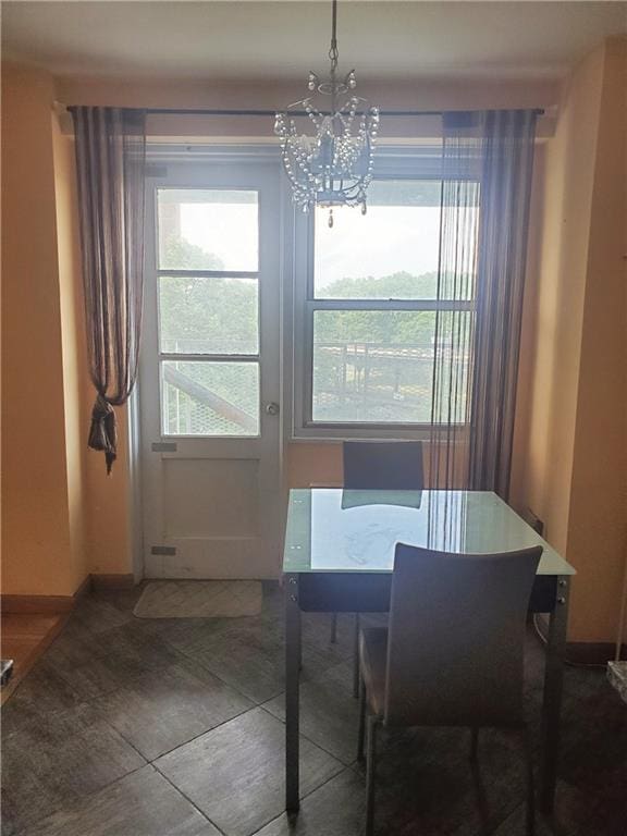 dining area with a healthy amount of sunlight, an inviting chandelier, and baseboards