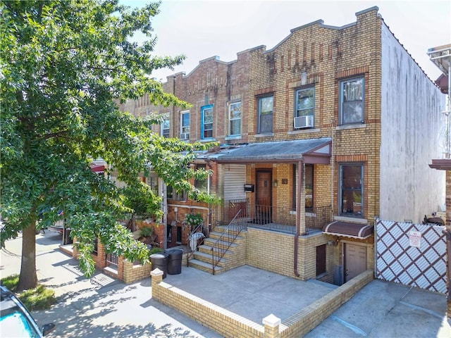 view of front of property featuring cooling unit and brick siding