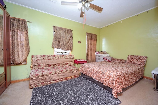 bedroom featuring ornamental molding, light colored carpet, baseboards, and a ceiling fan