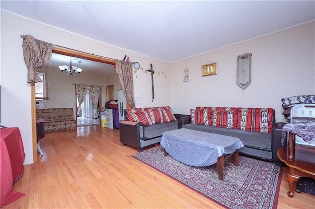 living area with an inviting chandelier, stairway, and wood finished floors