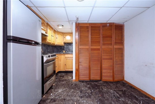 kitchen featuring decorative backsplash, a drop ceiling, dark countertops, stainless steel appliances, and light brown cabinets