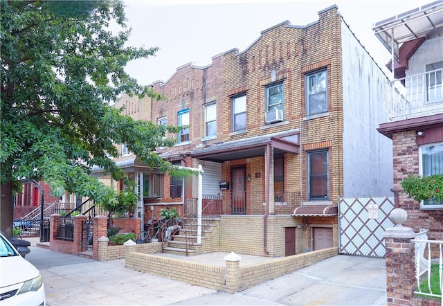 view of front of house featuring stairway and brick siding