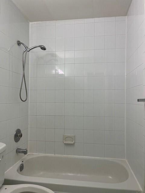 bathroom with tiled shower / bath and toilet