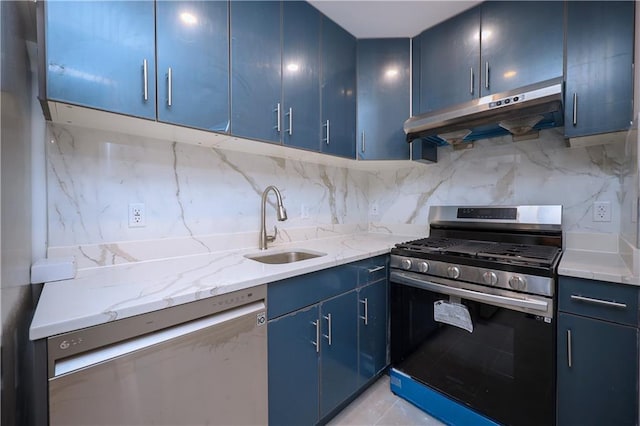 kitchen featuring stainless steel appliances, blue cabinetry, sink, and light stone counters