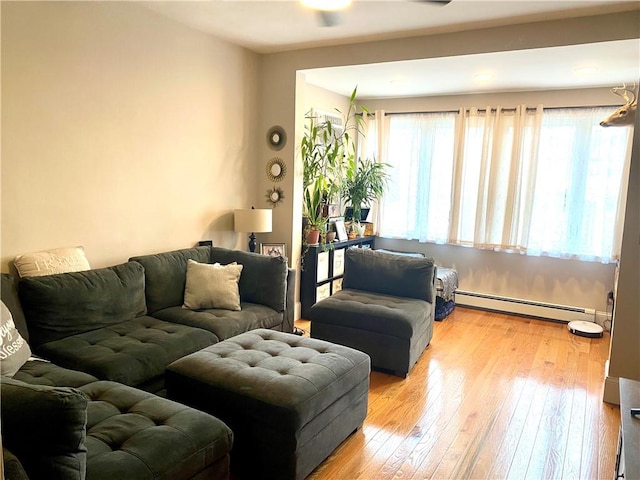 living room with light wood-type flooring and a baseboard heating unit