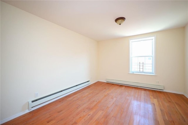 spare room featuring light hardwood / wood-style floors and a baseboard heating unit