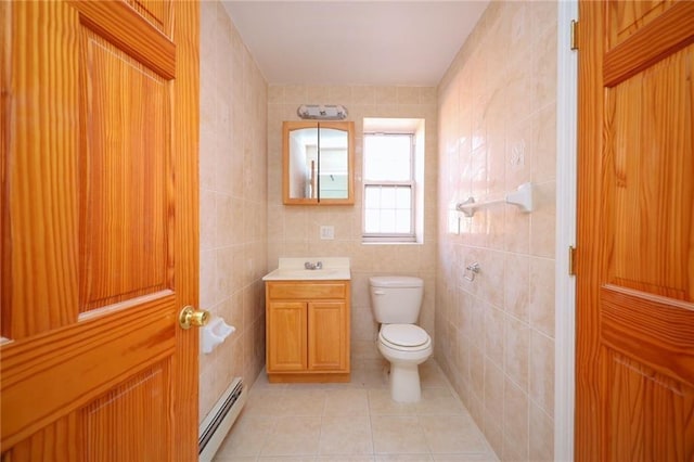 bathroom featuring tile patterned flooring, toilet, tile walls, and a baseboard heating unit