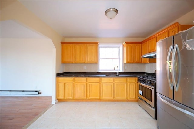 kitchen featuring backsplash, stainless steel appliances, baseboard heating, sink, and range hood