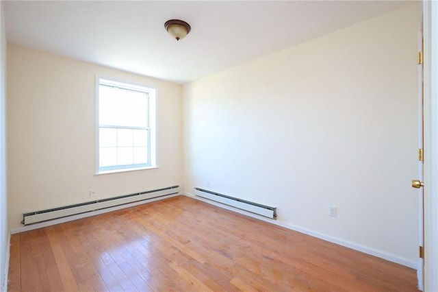 empty room featuring light wood-type flooring and baseboard heating