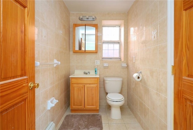 bathroom with tile patterned floors, vanity, a baseboard heating unit, tile walls, and toilet