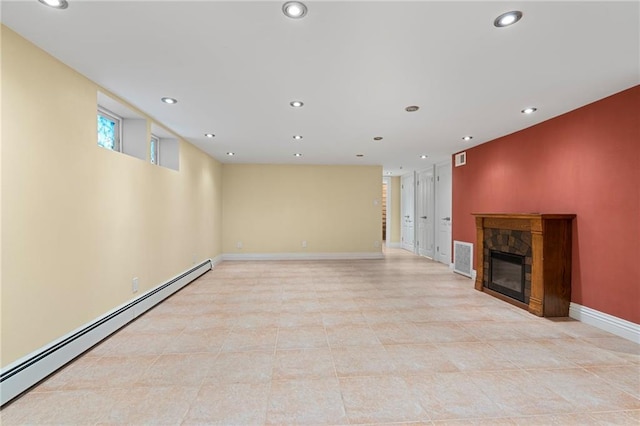 unfurnished living room with a baseboard radiator and a stone fireplace