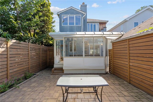 back of property featuring a patio area and a sunroom