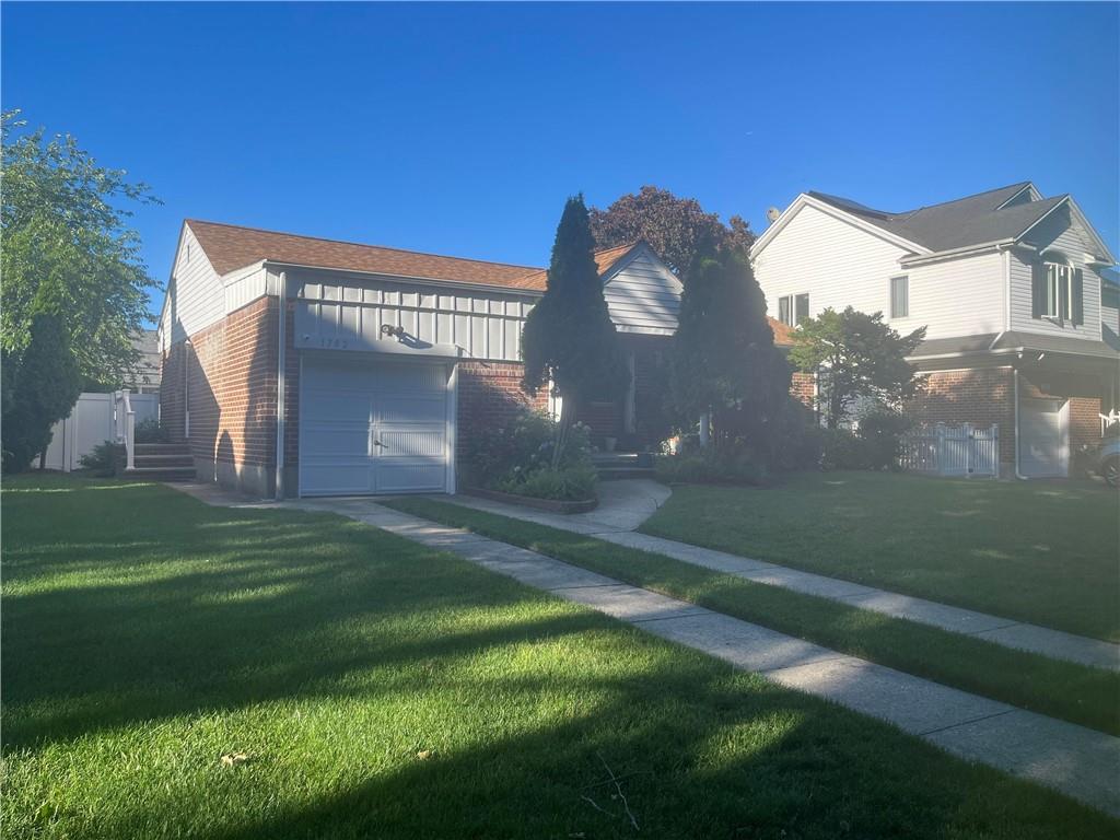 view of front of property featuring a front yard and a garage