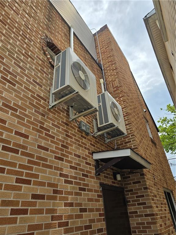 exterior space featuring ac unit and brick siding