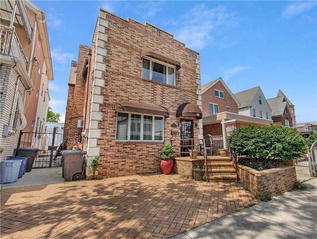 view of front of property with brick siding and fence