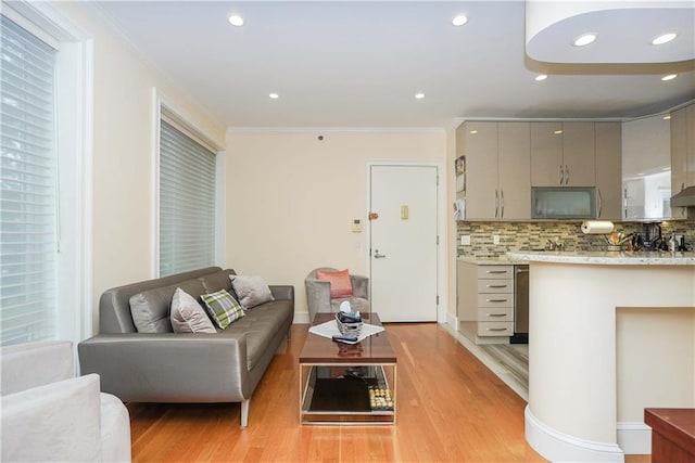 living room featuring light wood finished floors, recessed lighting, and crown molding