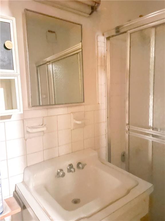 bathroom featuring a shower stall and tile walls