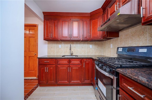 kitchen with sink, decorative backsplash, gas stove, and dark stone counters