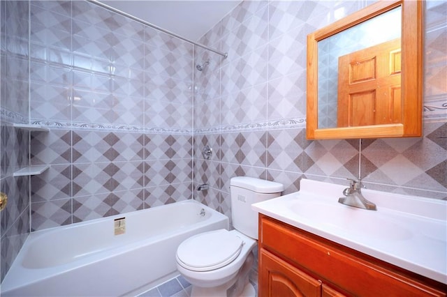 full bathroom with toilet, tile walls, tile patterned floors, vanity, and tiled shower / bath combo