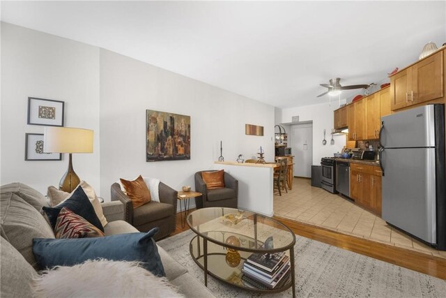 living room featuring ceiling fan and light hardwood / wood-style flooring