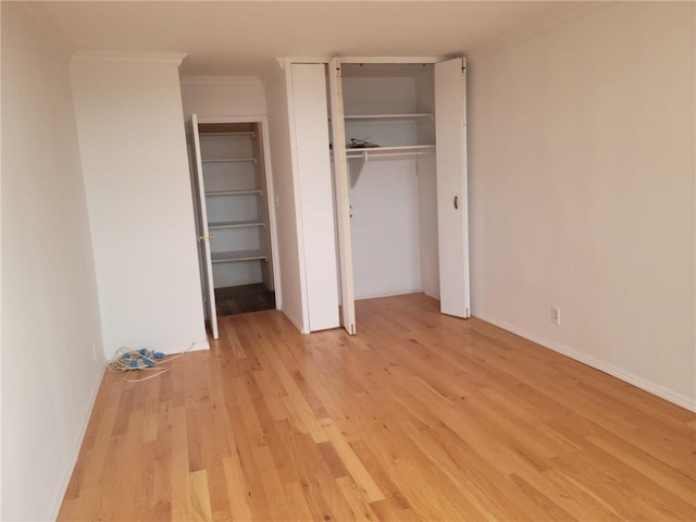 unfurnished bedroom featuring ornamental molding and light hardwood / wood-style flooring