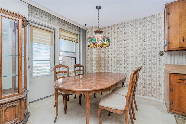 dining space with baseboards and wallpapered walls