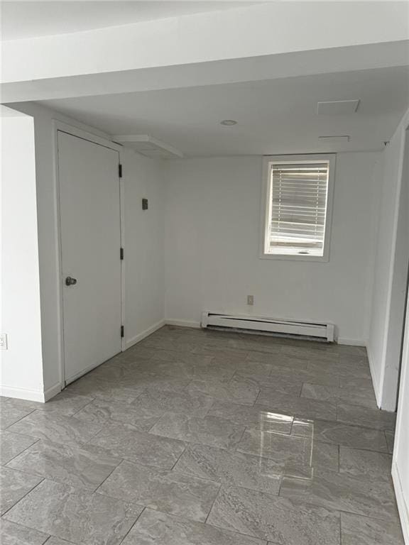 empty room with baseboard heating and baseboards