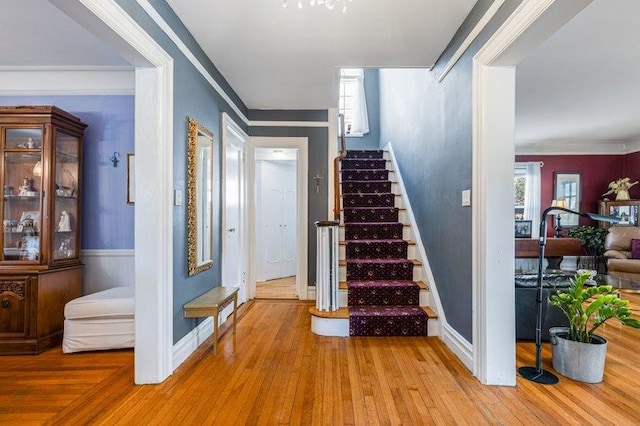 staircase featuring ornamental molding and wood-type flooring