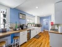 kitchen with white cabinets, a breakfast bar area, and light wood-type flooring