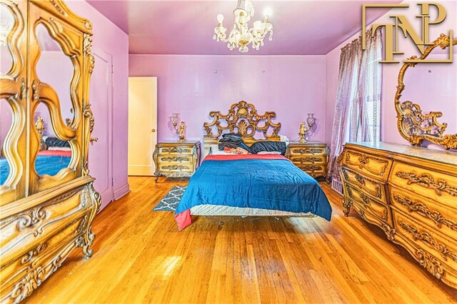 bedroom featuring wood finished floors and a notable chandelier