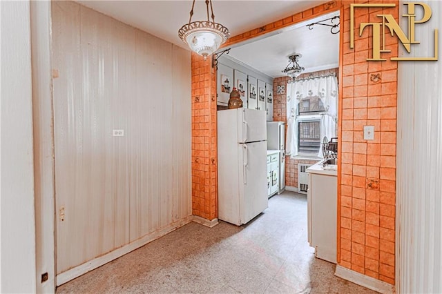 kitchen featuring freestanding refrigerator, light countertops, radiator, and light floors