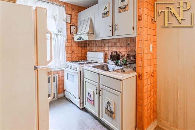kitchen featuring light countertops, premium range hood, a sink, light floors, and white appliances