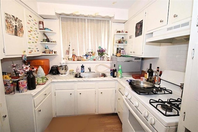 kitchen with white cabinets, light hardwood / wood-style flooring, sink, and gas range gas stove