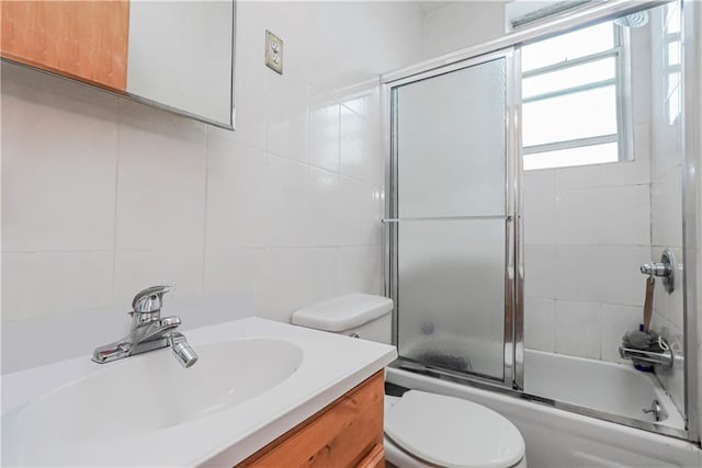 full bathroom with shower / bath combination with glass door, vanity, tasteful backsplash, and toilet